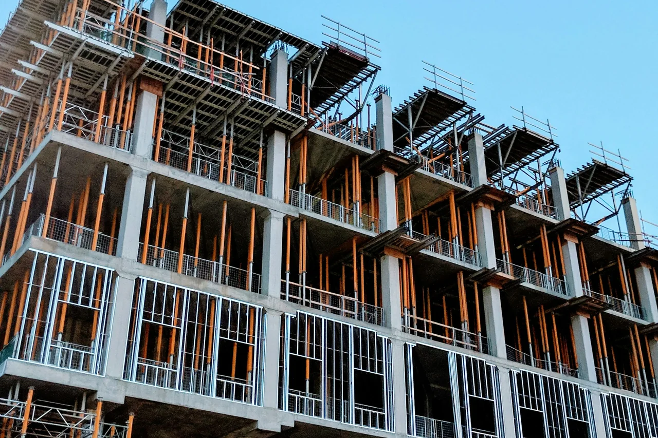Concrete building frame and temporary supports at a construction site.